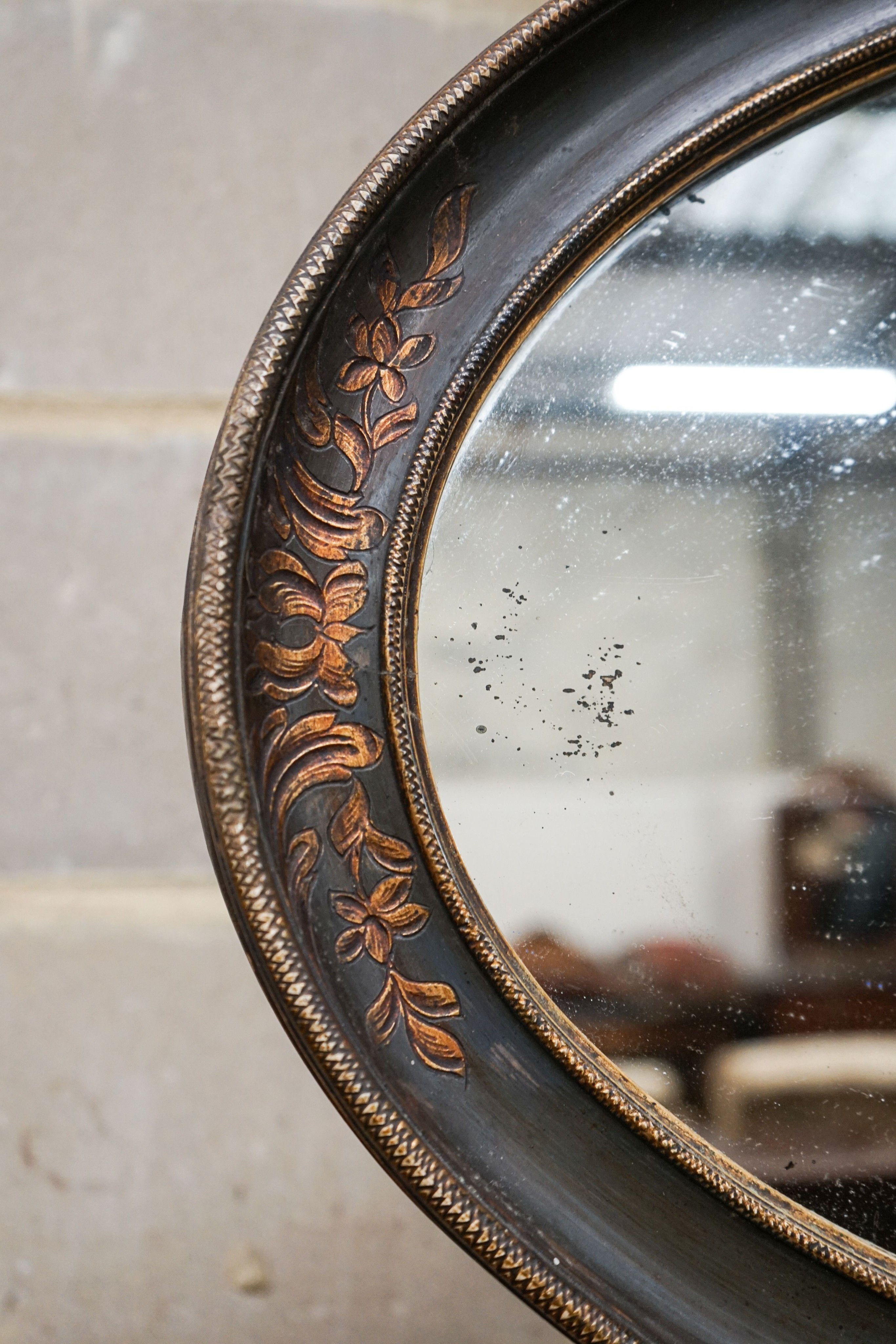 An oval painted parcel gilt bevelled wall mirror, width 84cm, height 51cm